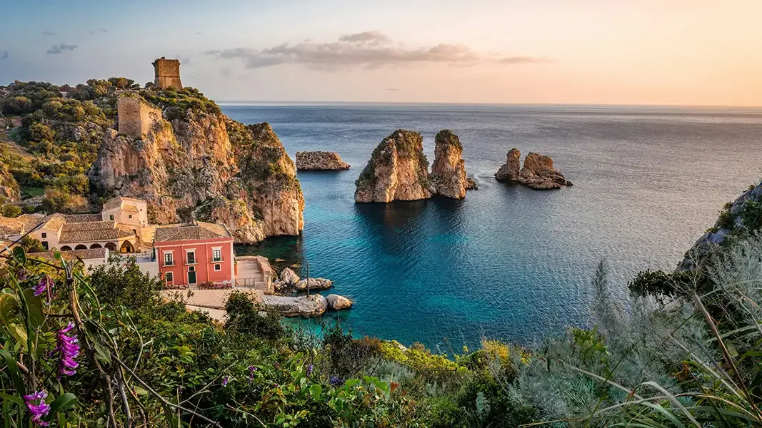 Charming coastal village and calm harbor waters along the shoreline of Favignana Island.
