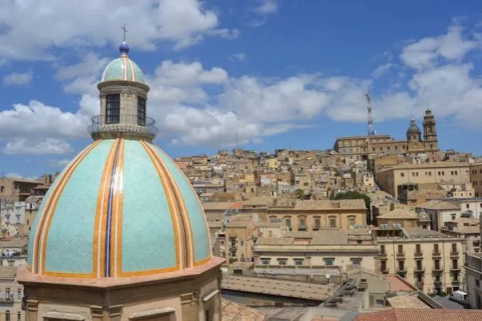 Scenic overlook of the lush Sicilian countryside and historic center of Caltagirone.