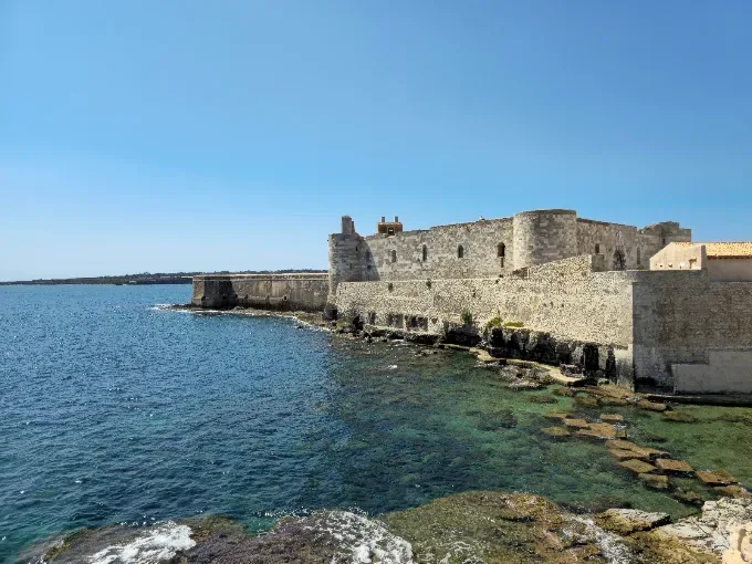 Breathtaking outdoor wedding setup by the sea at Castello Maniace in Syracuse
