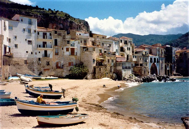 Warm sunlight illuminating the picturesque stone alleys and classic architecture of old town Cefalù.