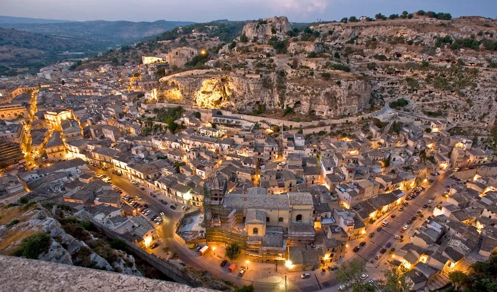 t: Scenic panoramic overlook of the historic rooftops, hills, and baroque landmarks of Scicli.