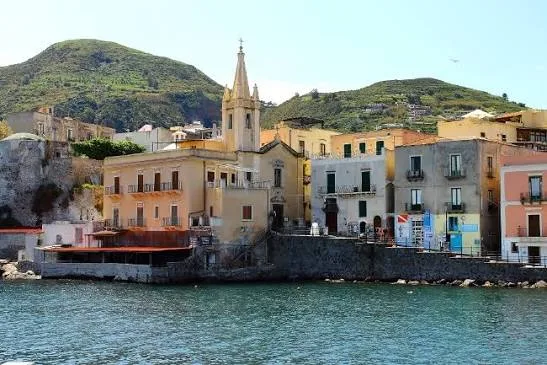 Warm golden hour sunset casting light over the scenic coastal cliffs and sea in Lipari, Sicily.
