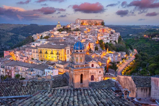 Bride and groom holding hands in front of the baroque Duomo di San Giorgio in Ragusa Ibla, Sicily.