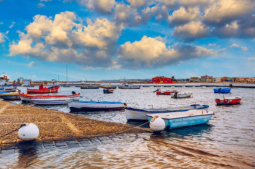 Scenic waterfront landscape overlooking traditional wooden boats and calm blue waters in Marzamemi.