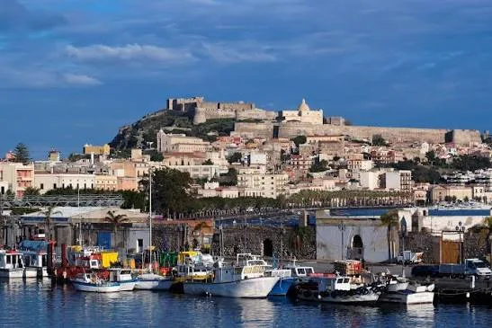 t: Panoramic view of the scenic coastal peninsula and turquoise Mediterranean waters in Milazzo, Sicily.