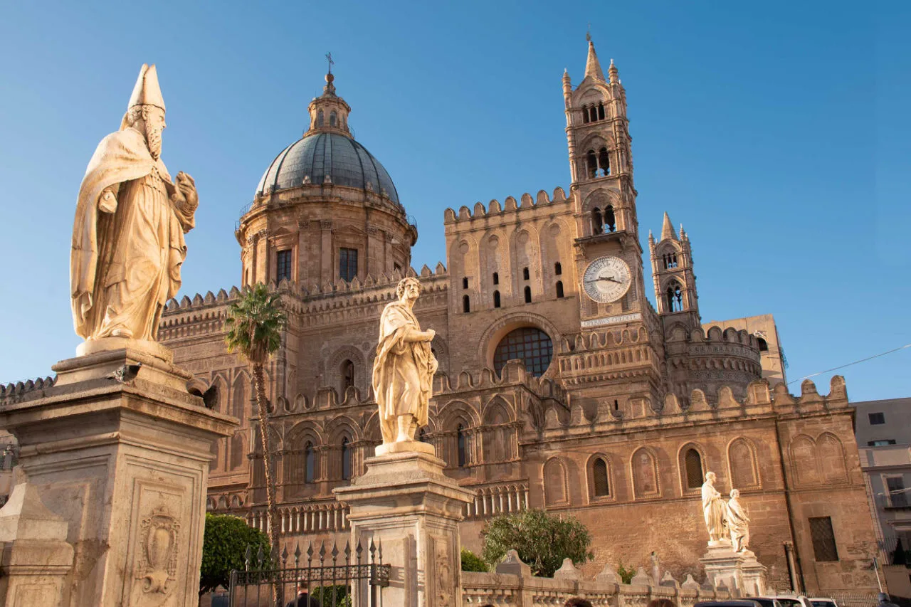 Picturesque cobblestone alley with traditional balconies and warm sunlight in Palermo.
