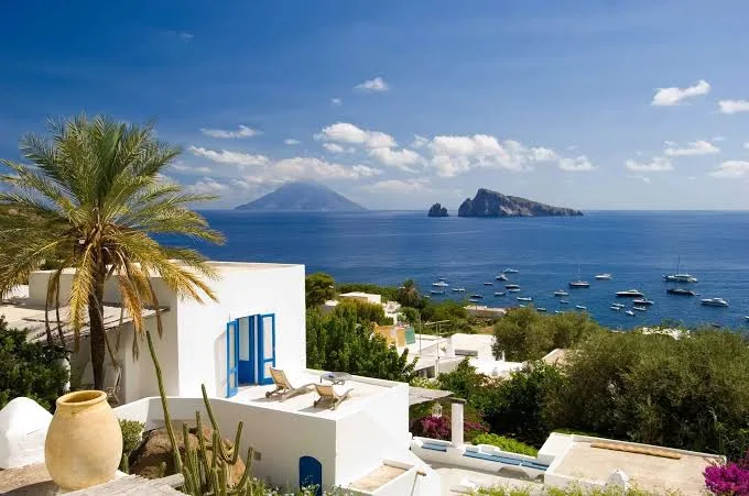 Warm golden hour sunset casting light over the scenic island coastline and horizon in Panarea, Sicily.