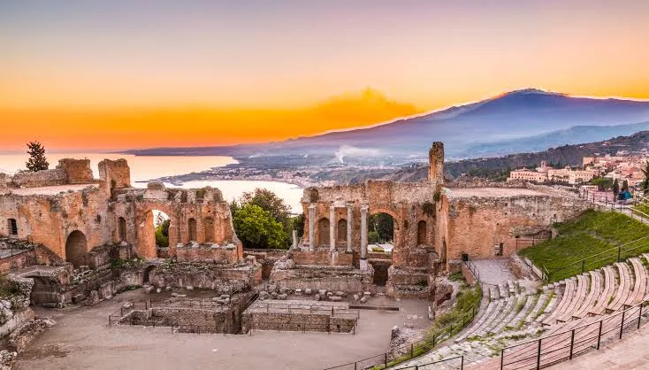 Warm golden hour sunlight illuminating the scenic architectural landscape of Piazza Armerina, Sicily.
