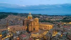 Panoramic view over the historic hilltop townscape and rolling green hills of Piazza Armerina, Sicily.