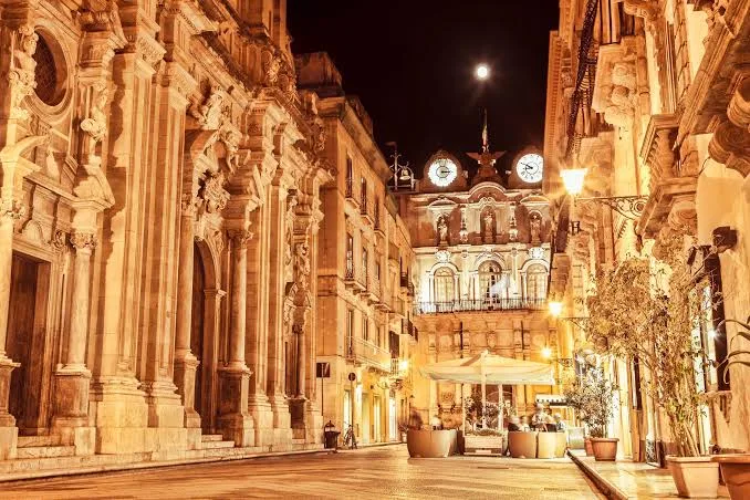 Picturesque cobblestone street lined with traditional Sicilian architecture and wrought-iron balconies in Trapani.