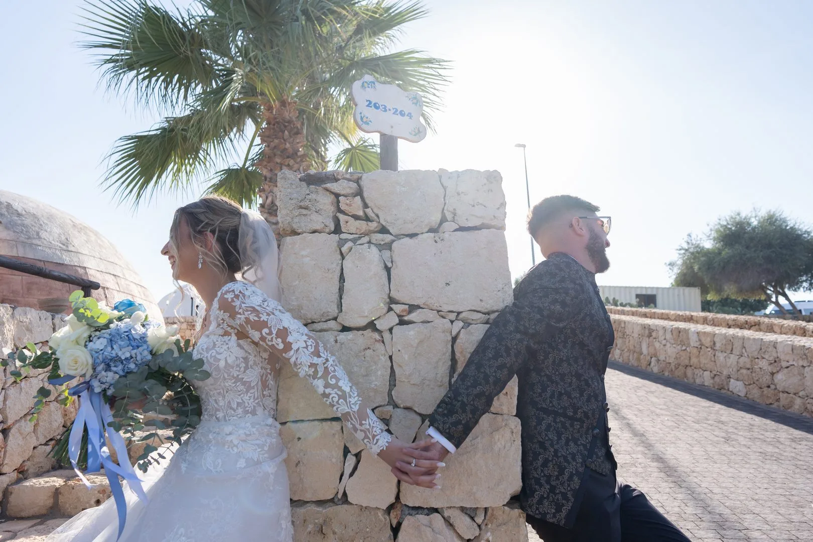 Bride and groom touching hands without seeing each other