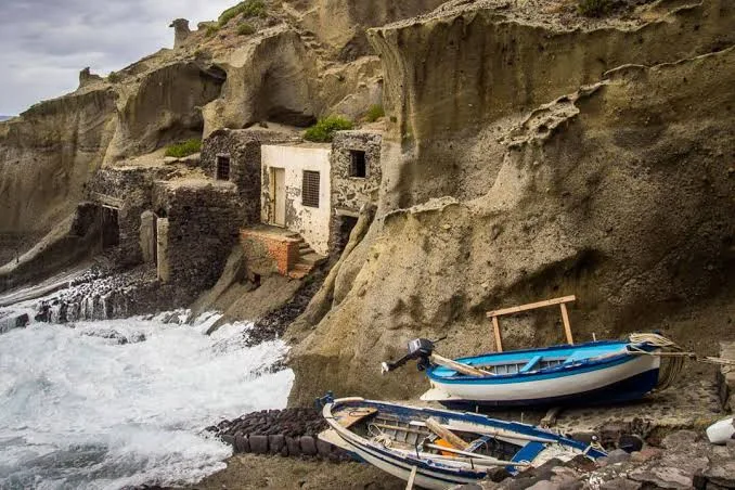 Dramatic view of natural volcanic cliffs overlooking the turquoise Mediterranean waters in Salina.
