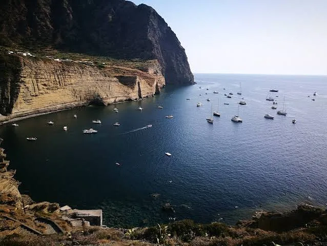 Warm golden hour sunset illuminating the sea cliffs and pristine coastline of Salina, Sicily.