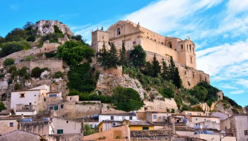 View of the baroque Church of San Bartolomeo nestled in the limestone canyon of Scicli, Sicily.