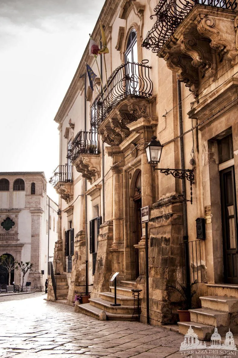 Characteristic stone balconies and ornate baroque details of Palazzo Beneventano in Scicli.