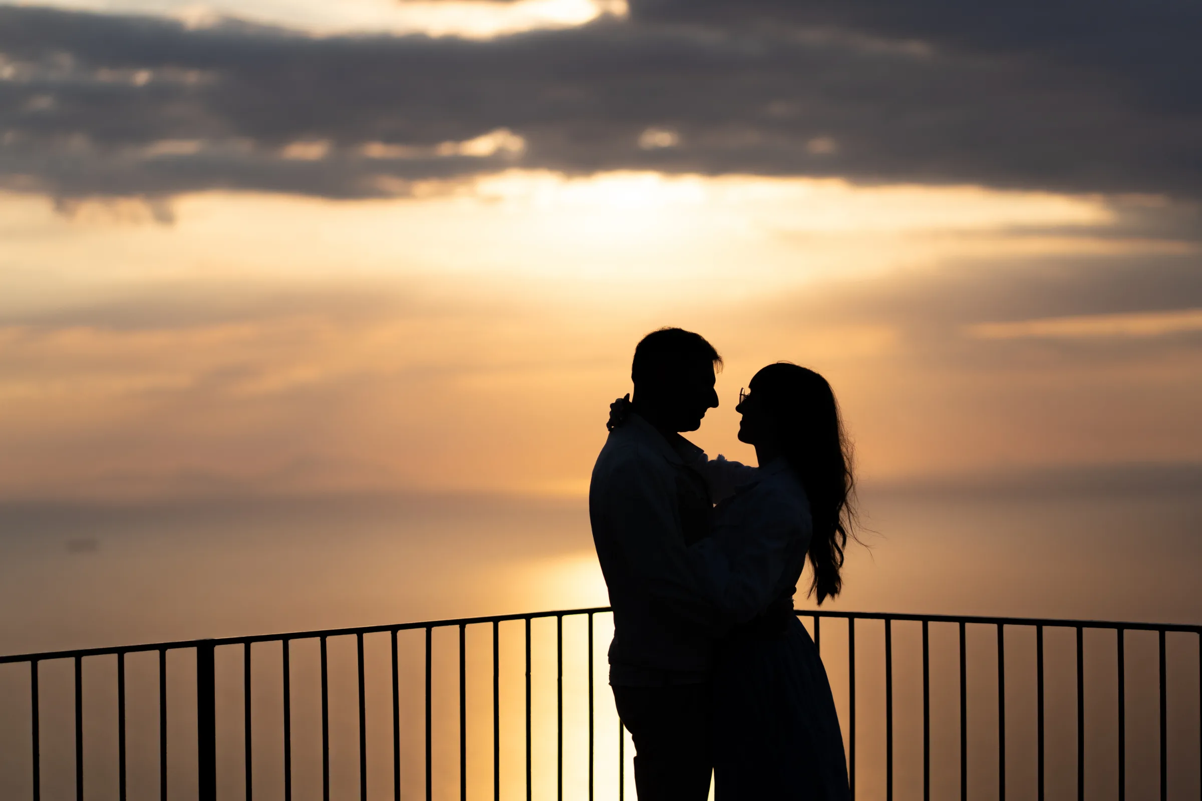 bride and groom walking along the Sicilian coast during sunset wedding