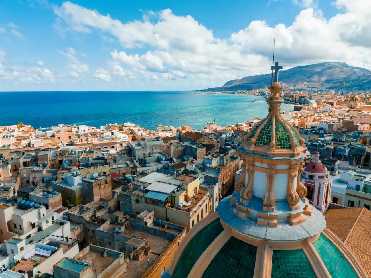 Panoramic coastal view of the historic town stretching into the crystal-clear Mediterranean Sea in Trapani, Sicily.